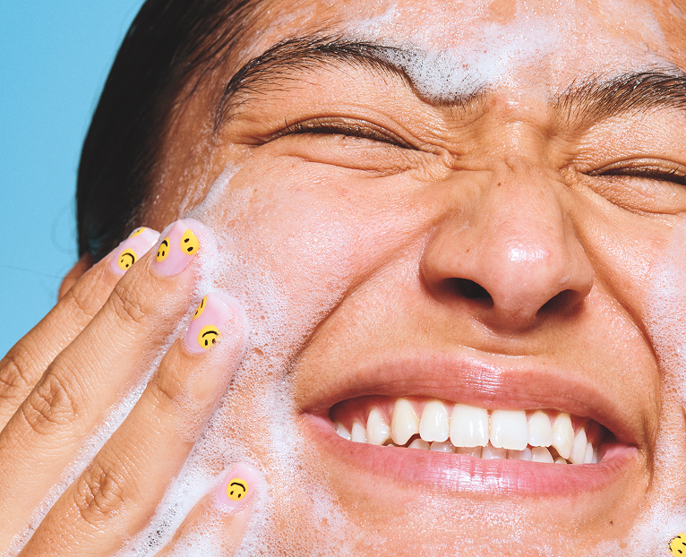 Model applying holy hydration clean freak daily cleanser on face